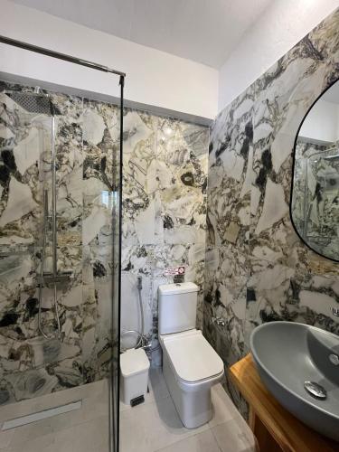 a bathroom with a shower and a toilet and a sink at Avgoustina Venus Studios in Benitses