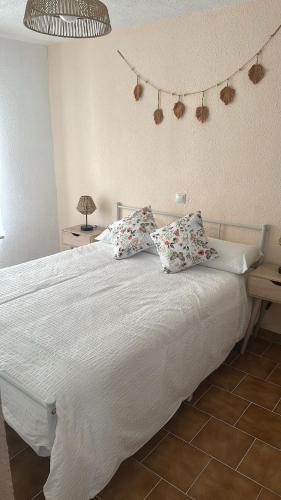 a bedroom with a large white bed with pillows at Casa Manito in El Barraco