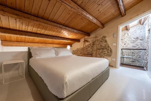 a bedroom with a large bed with a wooden ceiling at Borgo Baccile by Vini Fantini in Crecchio