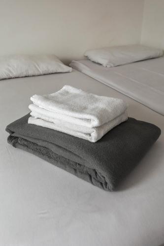 a pile of towels sitting on top of a bed at Casa Ecotrips Barra Funda - Hostel in São Paulo