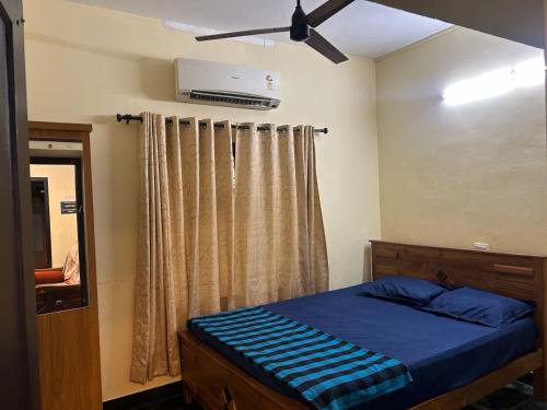 a bedroom with a bed and a ceiling fan at Bluebell Homes Near Beypore Beach Kozhikode in Kozhikode
