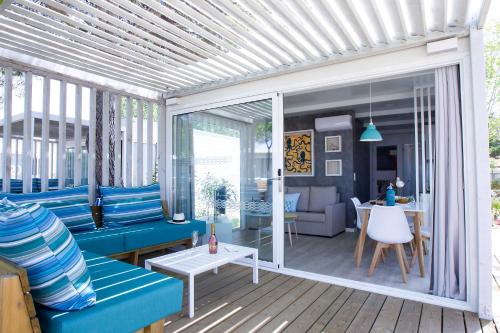 a screened in porch with a blue couch and a table at Tamarit Beach Resort in Tarragona