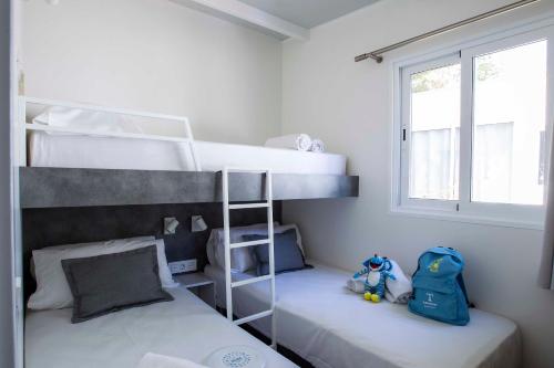 a bedroom with two bunk beds and a teddy bear at Tamarit Beach Resort in Tarragona