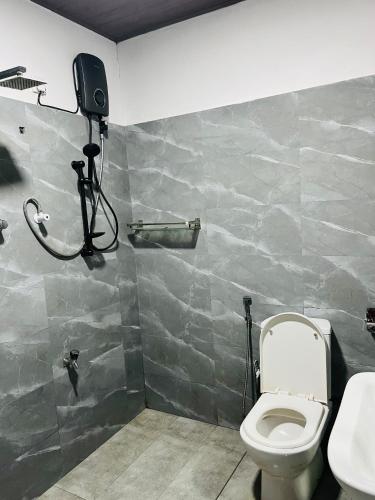 a bathroom with a toilet and a camera on the wall at Airport Kiyas Transit Villa Free Airport Pickup or Drop in Katunayaka