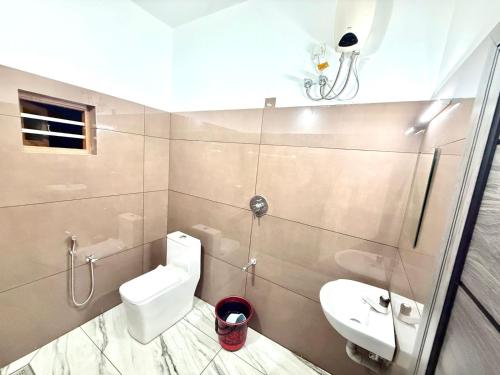 a bathroom with a toilet and a sink and a shower at Mridanga Homestay in Iritti