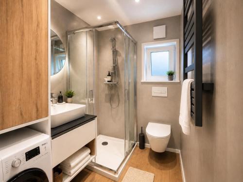 a bathroom with a shower and a toilet and a sink at Domki nad rzeką Narew in Ploski
