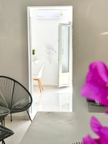 a living room with a chair and a mirror at V Angelo Prestige Rooms- Adults Only in Perissa