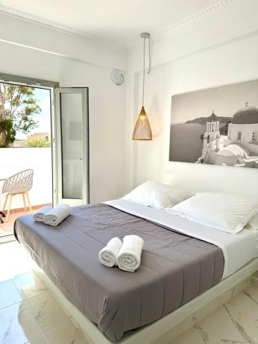a bedroom with a large bed with towels on it at V Angelo Prestige Rooms- Adults Only in Perissa