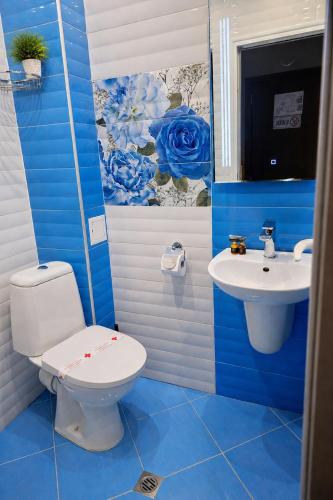 a blue bathroom with a toilet and a sink at Комплекс Кремен in Blagoevgrad