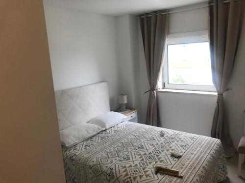 a bedroom with a bed and a window at HabiKuchta Foz in Figueira da Foz