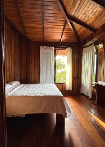 a bedroom with a large bed in a wooden room at Casa vacacional Tena Archidona in Tena