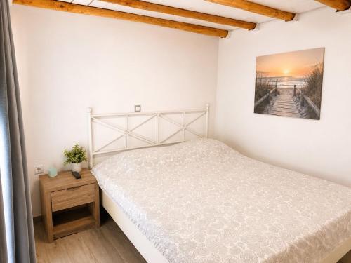 a white bedroom with a bed and a picture on the wall at Moraitis Studios in Skiros