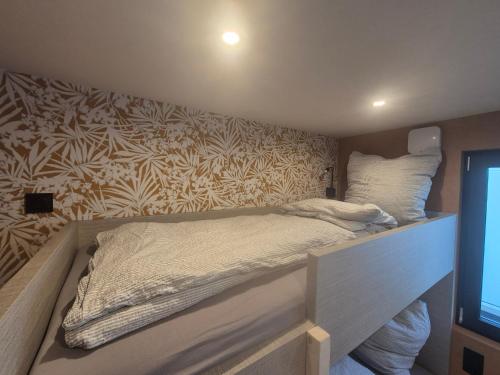 a bed in a room with a wall at Eifelchalet Mendig in Mendig