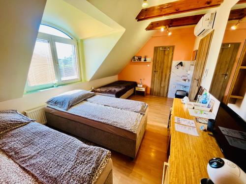 a bedroom with two beds and a table in it at Penzión Tyché in Šurany