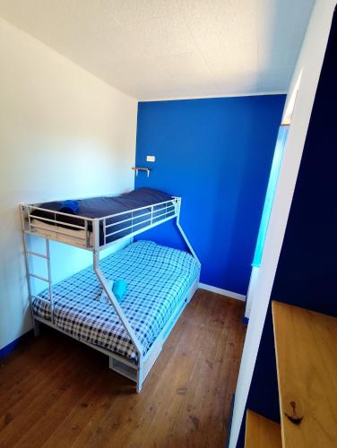 a bunk bed in a room with a blue wall at La Pépite in Sénac