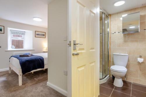 a bathroom with a toilet and a shower and a bed at 3 Bed in Dornoch oc-o44869 in Dornoch