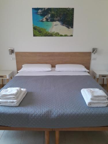 a bed with two towels sitting on top of it at Eliseo's rooms in Triei