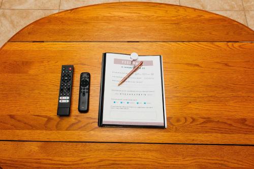 a table with a clipboard and two remote controls at NEW Desert Bloom Hideaway in Green Valley