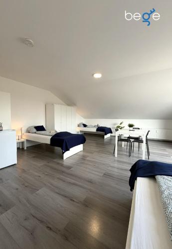 a room with two beds and a table and chairs at BEGE APARTMENTS WorkSpace in Marl