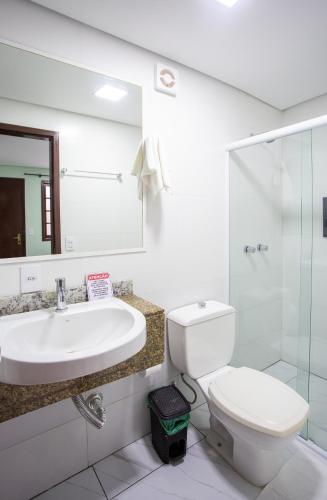 a bathroom with a sink and a toilet at POUSADA JURERE in Florianópolis