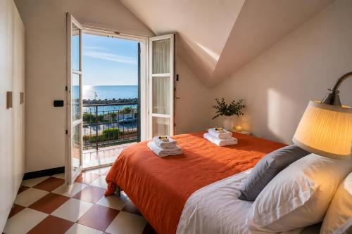 a bedroom with a bed and a large window at Giada Apartments in Moneglia