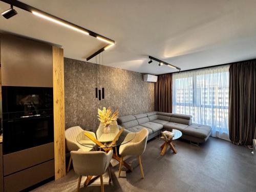 a living room with a couch and a table and chairs at Apartment Sonata in Varna City