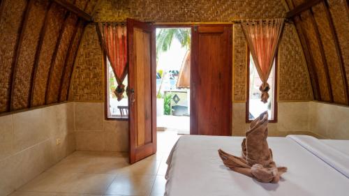 a room with a bed with a animal on it at Warna Cottage in Gili Trawangan