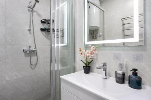 a bathroom with a white sink and a shower at Fayna Town Comfort #173 in Kyiv