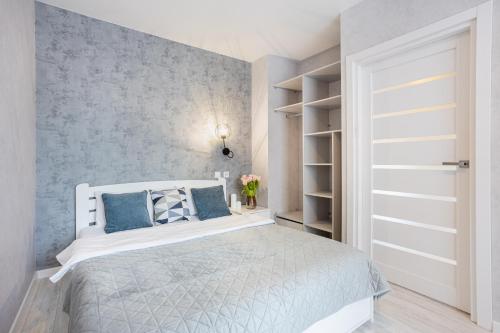 a bedroom with a white bed with blue walls at Fayna Town Comfort #173 in Kyiv