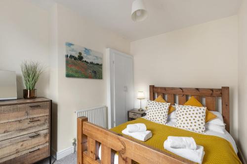 a bedroom with a wooden bed with towels on it at Park Crescent - Quaint Victorian Home With Free Parking in York