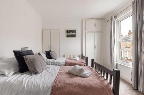 a bedroom with two beds with towels on them at Park Crescent - Quaint Victorian Home With Free Parking in York