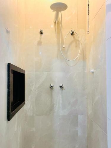 a bathroom with three hooks on the wall at Casa Central Px Matriz c/ Churrasqueira, 2 Suítes in Poços de Caldas