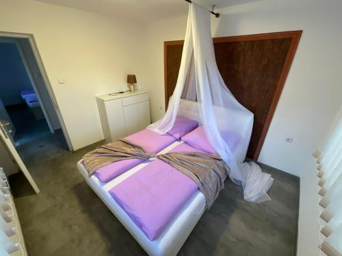 a bedroom with a bed with a mosquito net at Lohovo Arena in Bihać
