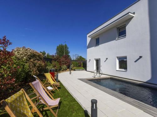 a backyard with a swimming pool and a house at ibis budget Strasbourg Sud Illkirch in Geispolsheim