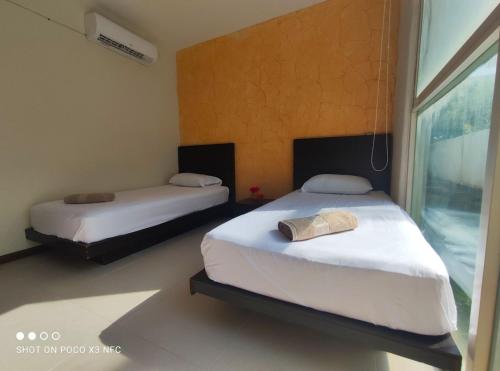 a bedroom with two beds and a window at Top Pool Condo in Ixtapa's Hotel Area in Ixtapa