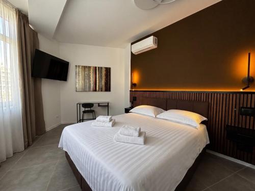 a bedroom with a large bed with two towels on it at Lumen - Bright Stay in Bucharest in Bucharest