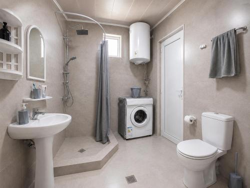 a bathroom with a toilet sink and a washing machine at panorama lasuriashi in Lasuriashi