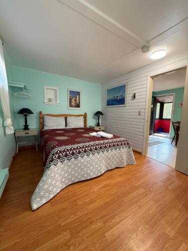 a bedroom with a bed and a wooden floor at Forest & Lake PEI Cottages in Murray Harbour