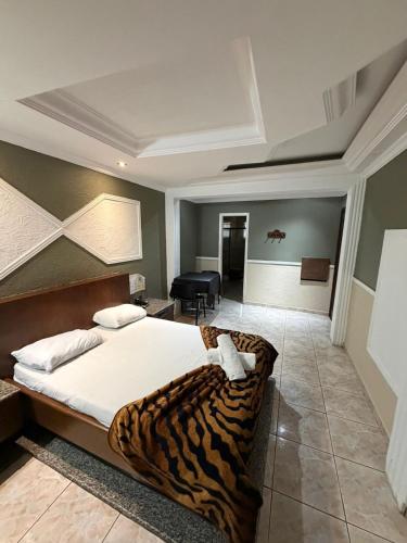 a hotel room with a tiger print bed in it at Hotel Vitória de Santos in Santos