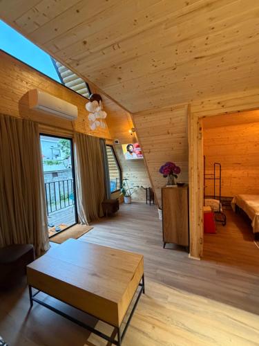 a living room with a wooden ceiling and a table at Chalet Marta in Kobuleti