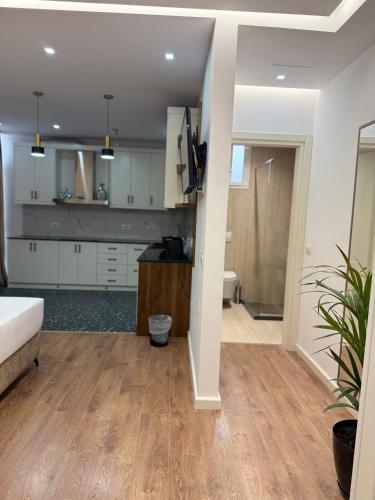 a kitchen and living room with white cabinets at Vila Marjana in Sarandë