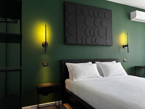 a bedroom with a white bed and a green wall at Lumen - Bright Stay in Bucharest in Bucharest