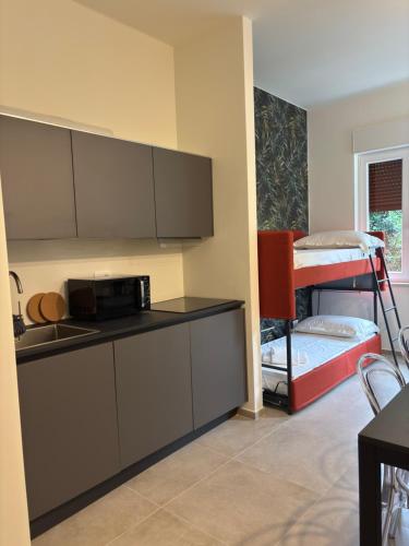 a kitchen with a microwave and a bunk bed at Hotel Delle Rose in San Bartolomeo al Mare