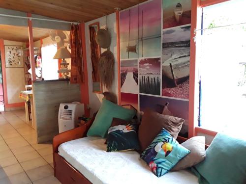 a living room with a couch with pillows on it at La Case du Pêcheur in La Trinité