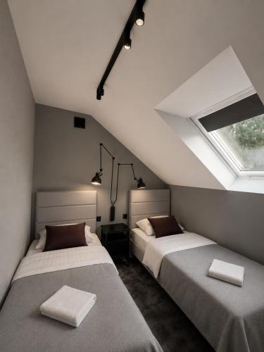 two beds in a room with a window at Willa Czarny Puzzel in Tarnowska Wola