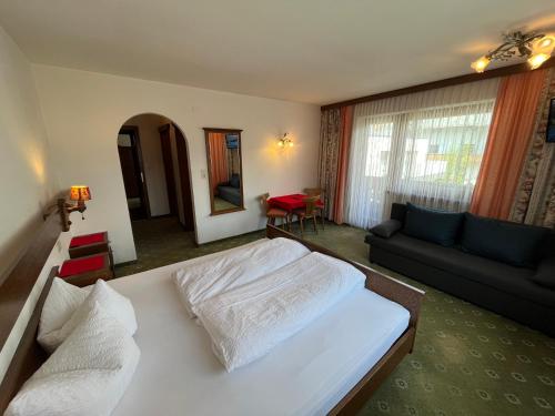 a bedroom with a bed and a living room at Haus Alpenblick in Serfaus
