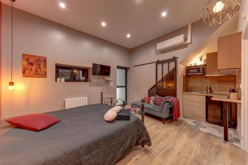 a bedroom with a large bed and a couch at Cachette Secrète in Bourgoin