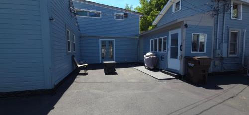 a blue house with a driveway next to a building at "Rustic Getaway A Charming & Cozy Cottage for Two or Four!" in Geneva