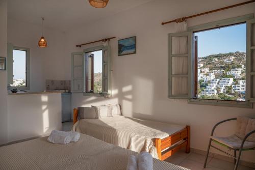 a bedroom with two beds and two windows at Marietta Studios Patmos in Skala