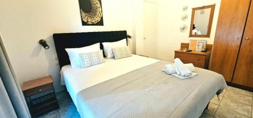 a bedroom with a large white bed with towels on it at Julsun apartment in Olympic Beach